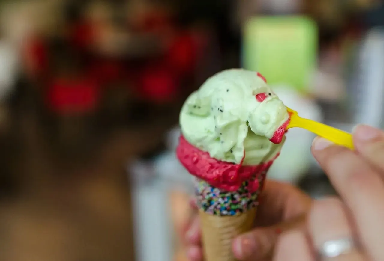 カラフルなスプリンクル付きアイスクリームコーンを食べているクローズアップ